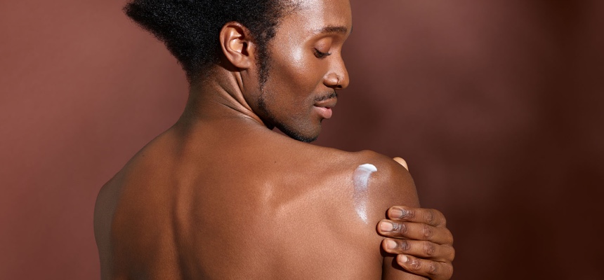 Man rubbing cream into his shoulder